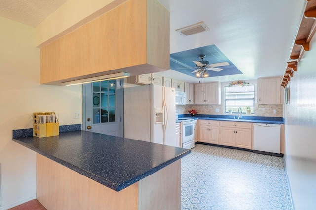 kitchen featuring light brown cabinets, kitchen peninsula, sink, white appliances, and ceiling fan