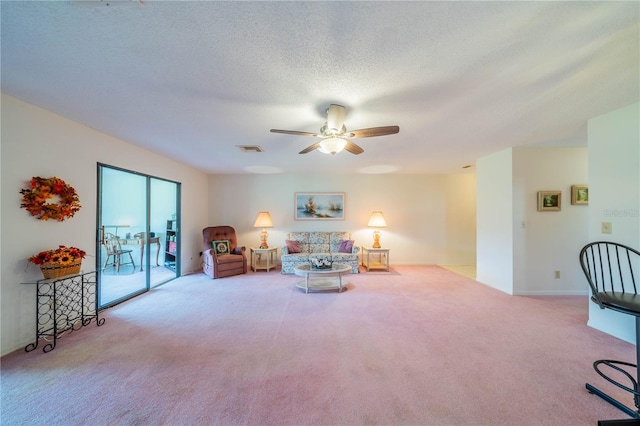 living room featuring a textured ceiling, light colored carpet, and ceiling fan