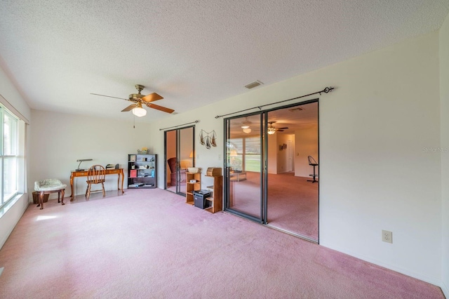 misc room featuring a textured ceiling, carpet floors, and ceiling fan