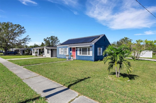 view of front of house featuring solar panels and a front lawn