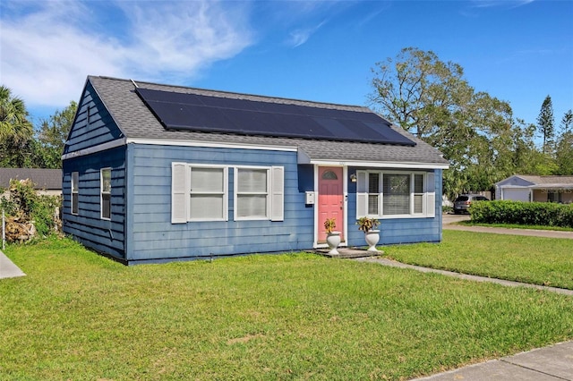 view of front of home featuring a front yard and solar panels