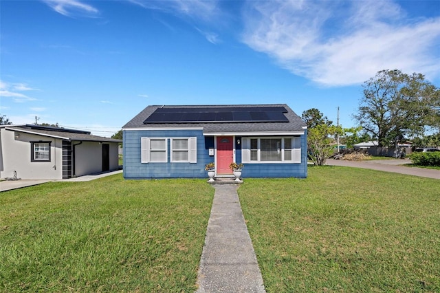 view of front facade featuring solar panels and a front lawn