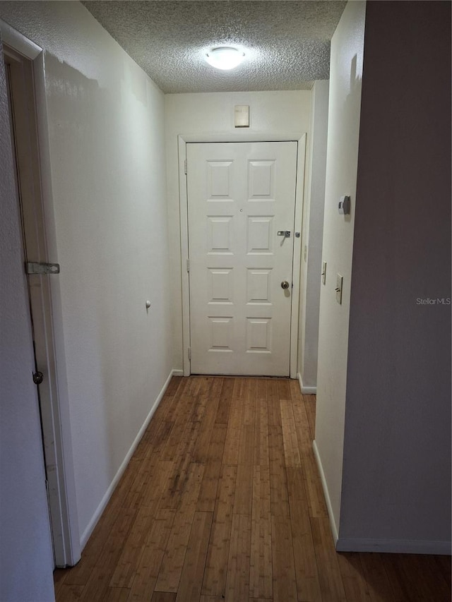 hallway featuring hardwood / wood-style flooring and a textured ceiling