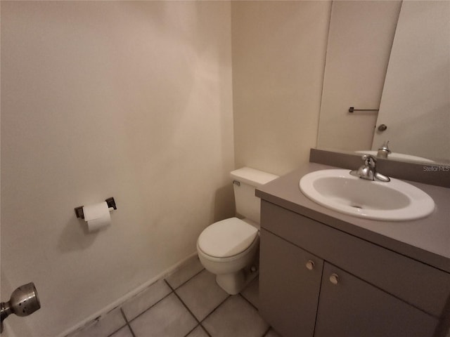 bathroom with toilet, vanity, and tile patterned flooring