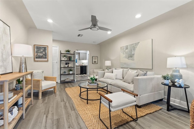 living room featuring light wood-type flooring and ceiling fan