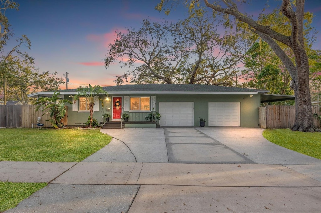 ranch-style home with a lawn and a garage