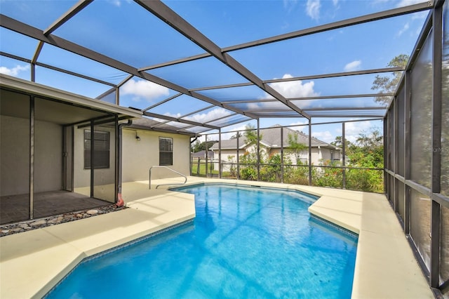 view of swimming pool with glass enclosure and a patio