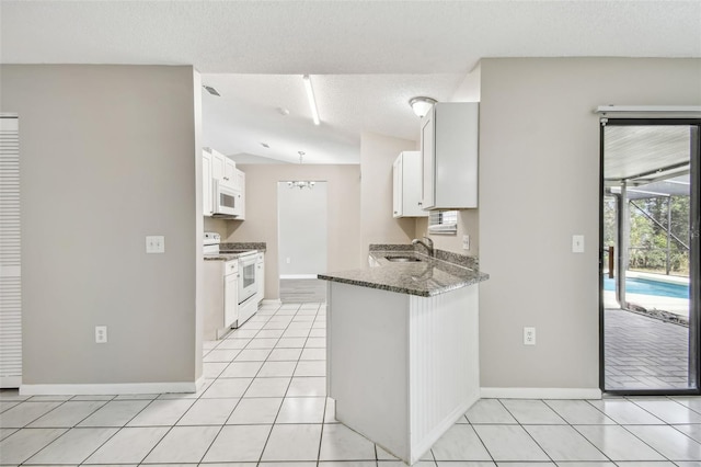 kitchen featuring dark stone counters, a textured ceiling, sink, white cabinetry, and white appliances