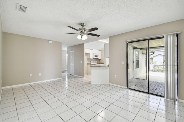 interior space with light tile patterned flooring, ceiling fan, and a textured ceiling