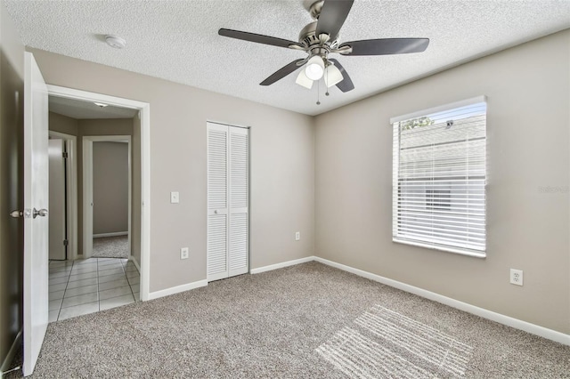 unfurnished bedroom featuring carpet floors, ceiling fan, and a closet