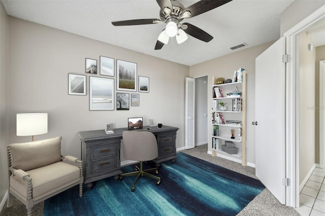 office area featuring ceiling fan, a textured ceiling, and light carpet