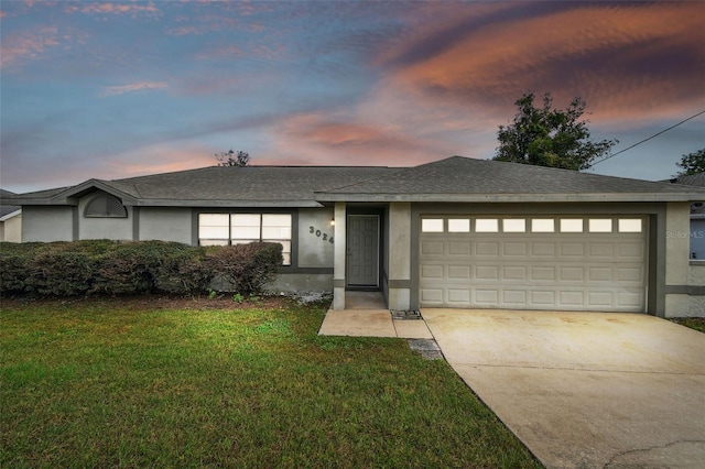 view of front of property with a garage and a lawn