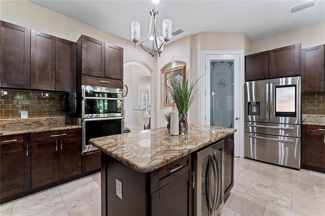 kitchen with a center island, hanging light fixtures, tasteful backsplash, appliances with stainless steel finishes, and wine cooler