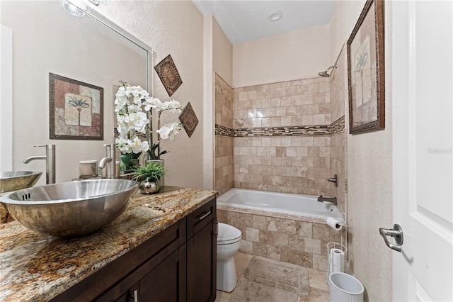 full bathroom with vanity, toilet, and tiled shower / bath combo