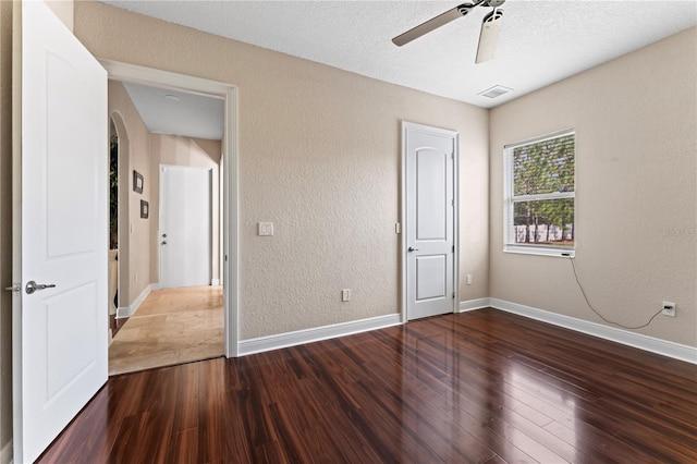 unfurnished bedroom featuring ceiling fan, wood-type flooring, and a textured ceiling