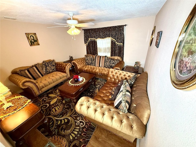 living room featuring a textured ceiling, hardwood / wood-style flooring, and ceiling fan