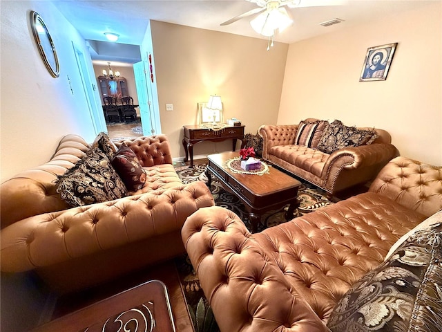 living room with ceiling fan with notable chandelier