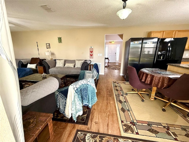 living room featuring a textured ceiling and dark hardwood / wood-style flooring