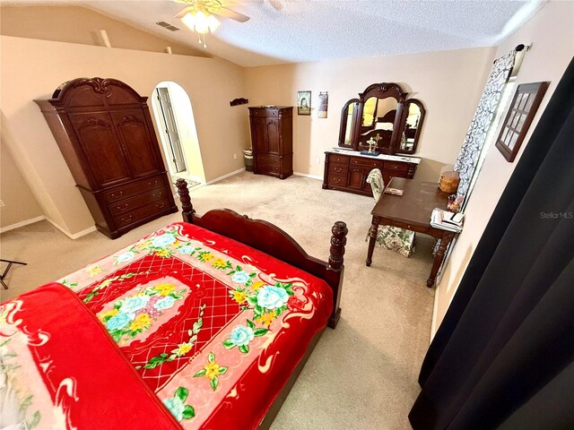 bedroom featuring a textured ceiling, carpet floors, vaulted ceiling, and ceiling fan