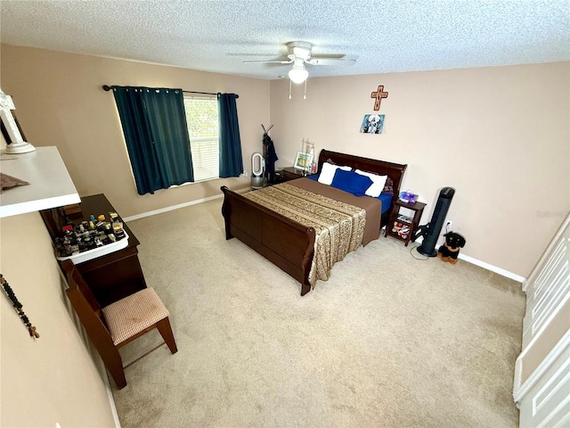 carpeted bedroom featuring a textured ceiling and ceiling fan