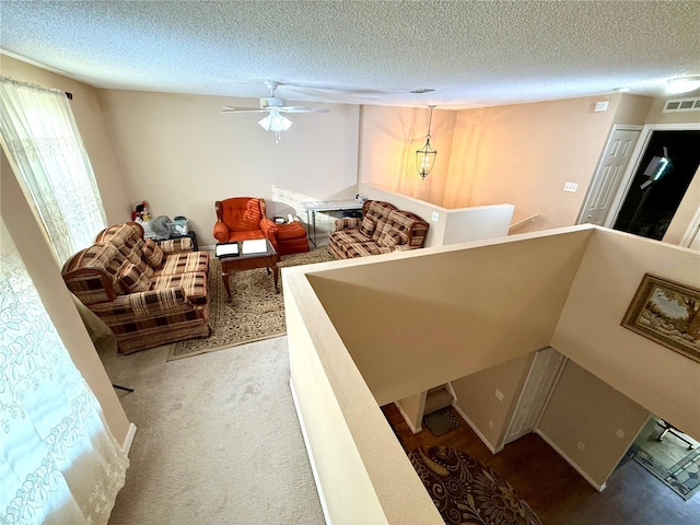 interior space with a textured ceiling and ceiling fan