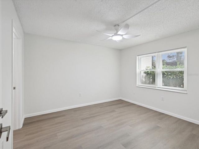 spare room with ceiling fan, a textured ceiling, and light hardwood / wood-style flooring