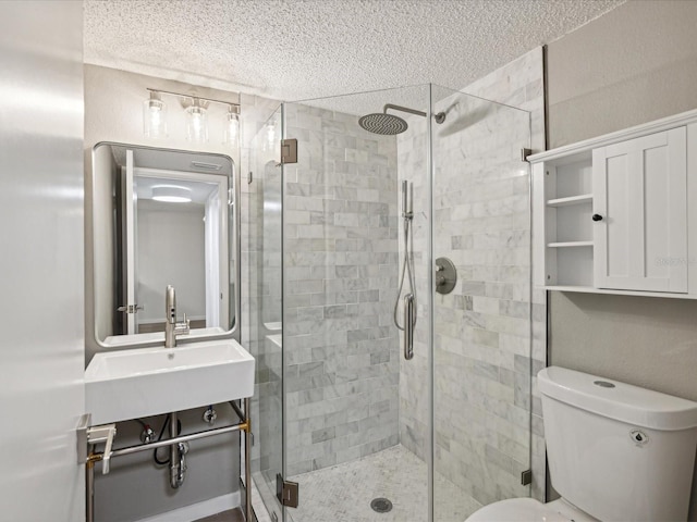 bathroom with toilet, sink, walk in shower, and a textured ceiling