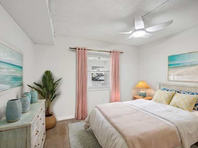 bedroom featuring ceiling fan, a textured ceiling, and light hardwood / wood-style flooring