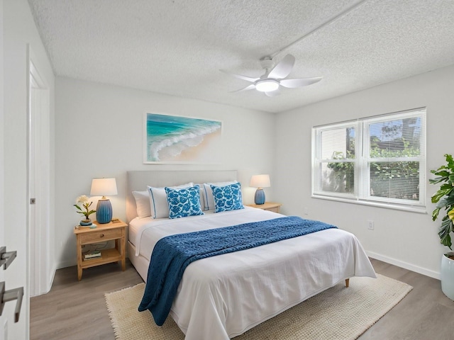 bedroom featuring ceiling fan, a textured ceiling, and hardwood / wood-style flooring