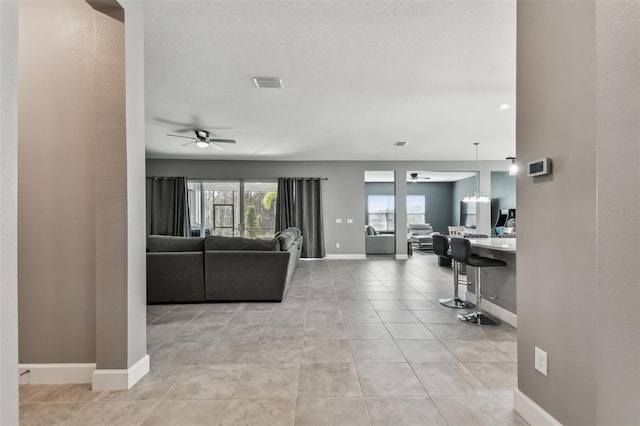 tiled living room with ceiling fan