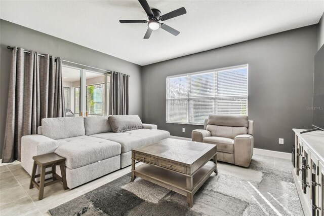 living room featuring a wealth of natural light, ceiling fan, and light tile patterned floors