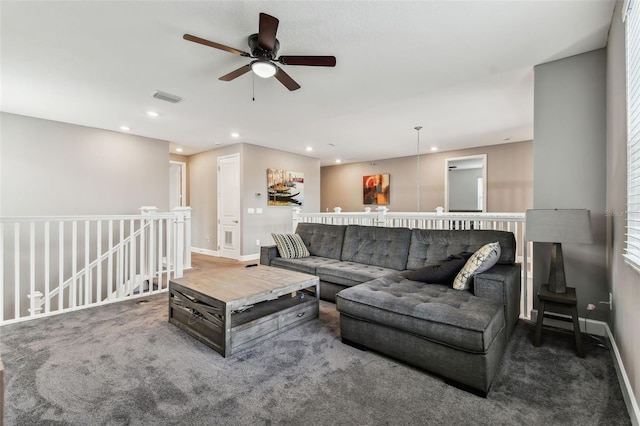 living room featuring a healthy amount of sunlight, dark colored carpet, and ceiling fan