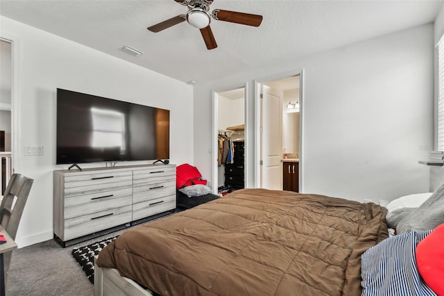 bedroom featuring a closet, a walk in closet, carpet flooring, ceiling fan, and ensuite bathroom