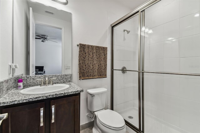 bathroom with ceiling fan, a shower with shower door, vanity, and toilet