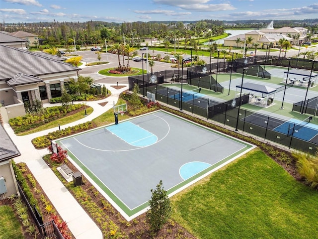 view of sport court featuring tennis court and a yard