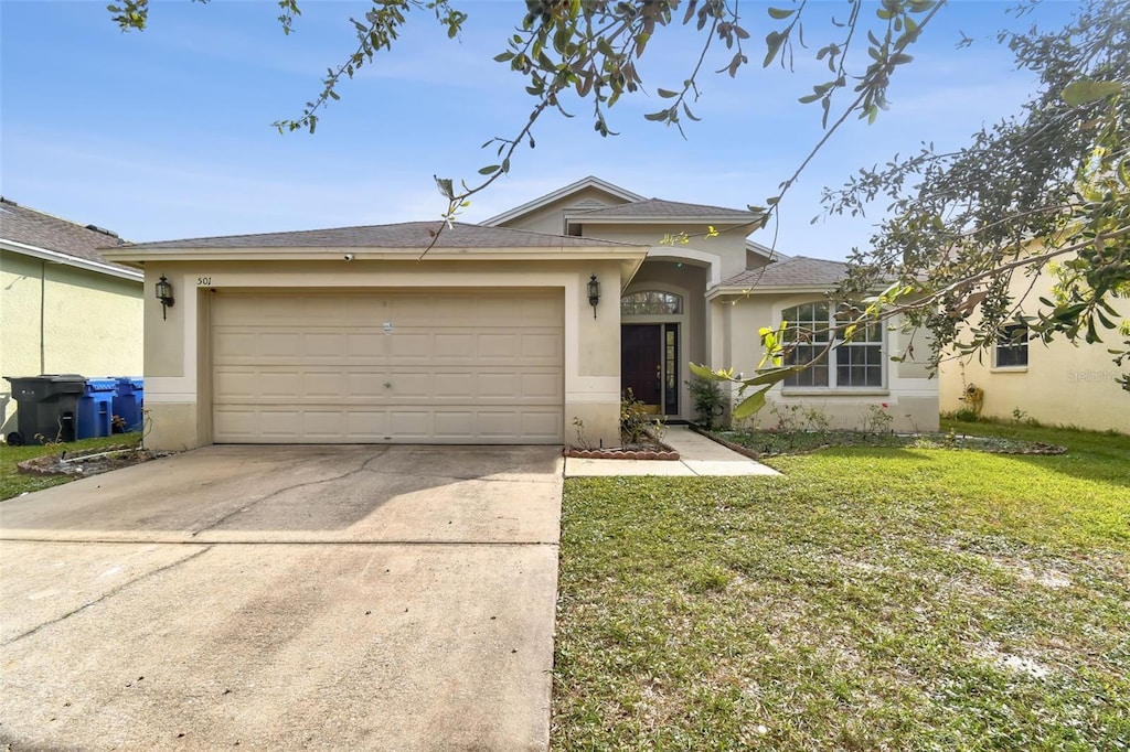 view of front of property with a front yard and a garage