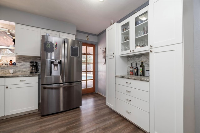 kitchen featuring white cabinetry, light stone counters, decorative backsplash, and stainless steel refrigerator with ice dispenser