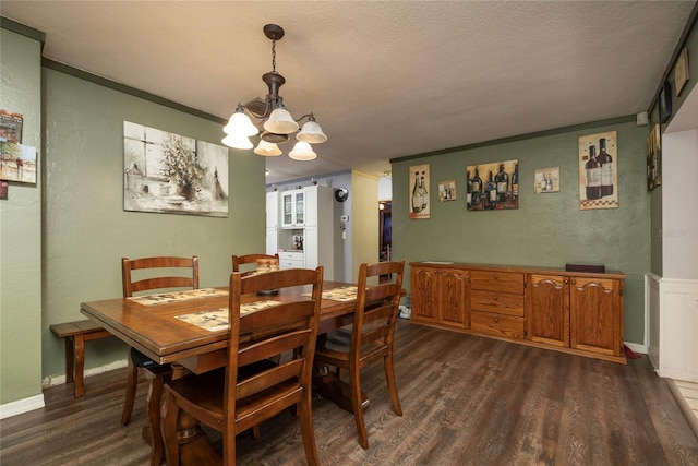 dining room featuring crown molding, dark wood-type flooring, a textured ceiling, and an inviting chandelier