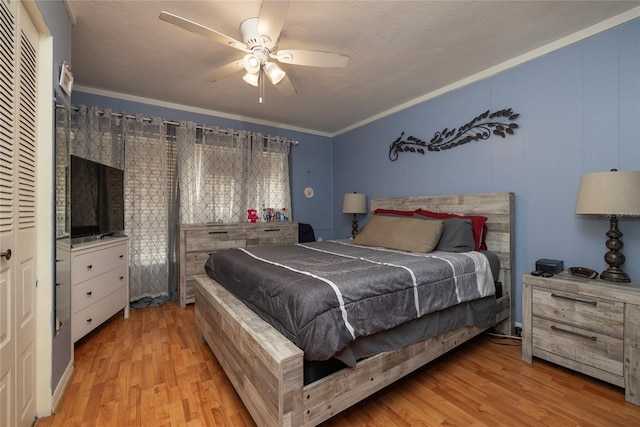 bedroom with light hardwood / wood-style flooring, a textured ceiling, ornamental molding, a closet, and ceiling fan