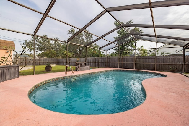 view of swimming pool featuring a yard, a patio area, and glass enclosure