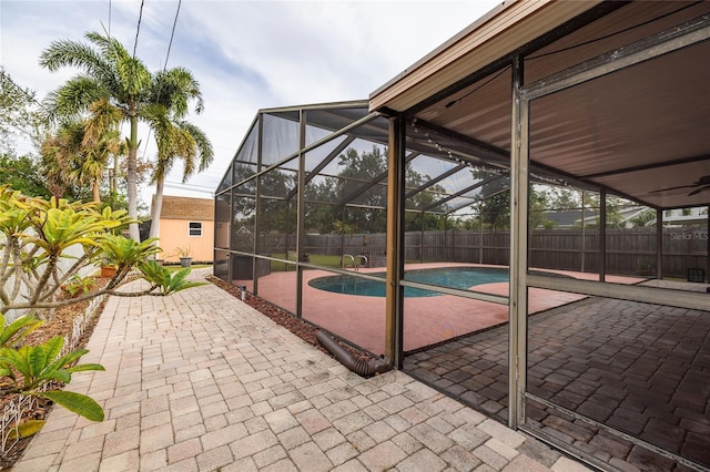 view of patio with a fenced in pool, a lanai, and a storage unit