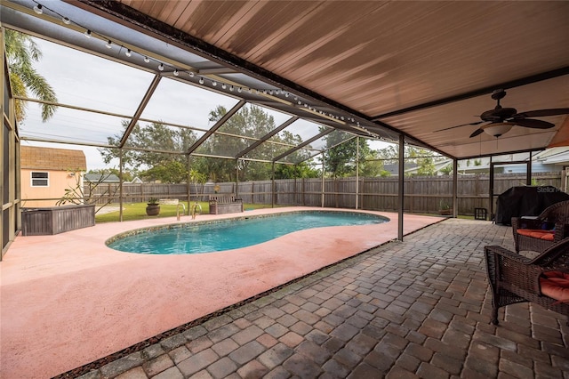 view of swimming pool featuring a lanai, a grill, ceiling fan, and a patio area