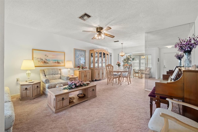 living room with light carpet, a textured ceiling, and ceiling fan