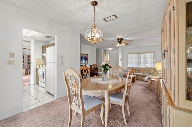 carpeted dining area with a textured ceiling and ceiling fan with notable chandelier