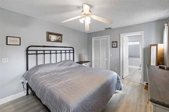 bedroom featuring hardwood / wood-style flooring, a closet, and a textured ceiling