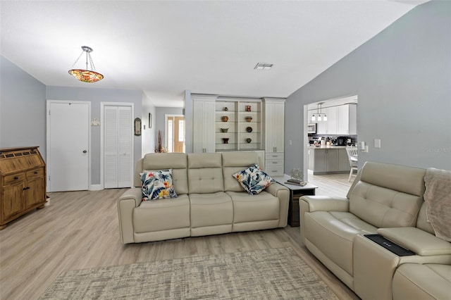 living room with lofted ceiling and light hardwood / wood-style flooring