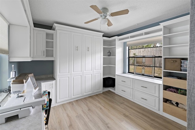 interior space featuring ceiling fan, a textured ceiling, and light hardwood / wood-style floors