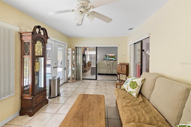 tiled living room with french doors and ceiling fan