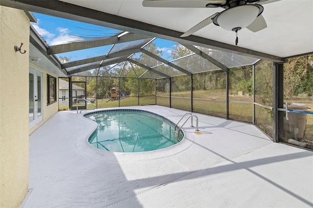 view of swimming pool with a yard, a patio area, and glass enclosure