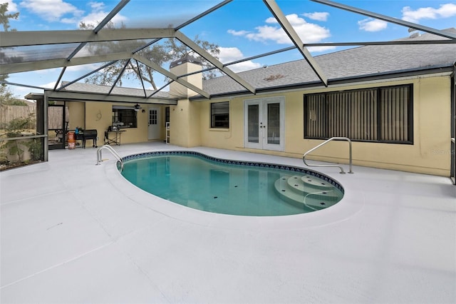 view of swimming pool with french doors, a lanai, and a patio